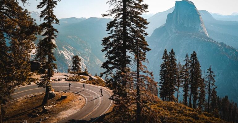 Cyclists on mountain road with scenic view.