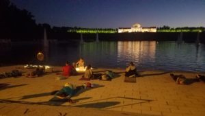 People relaxing by a lake at night.