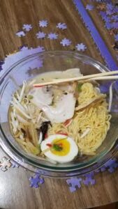 Bowl of ramen with egg and chopsticks.