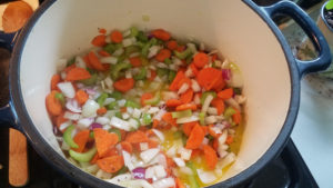 Chopped vegetables cooking in a large pot.