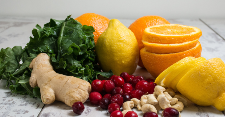 Fresh fruits, nuts, and ginger on a rustic wooden surface.